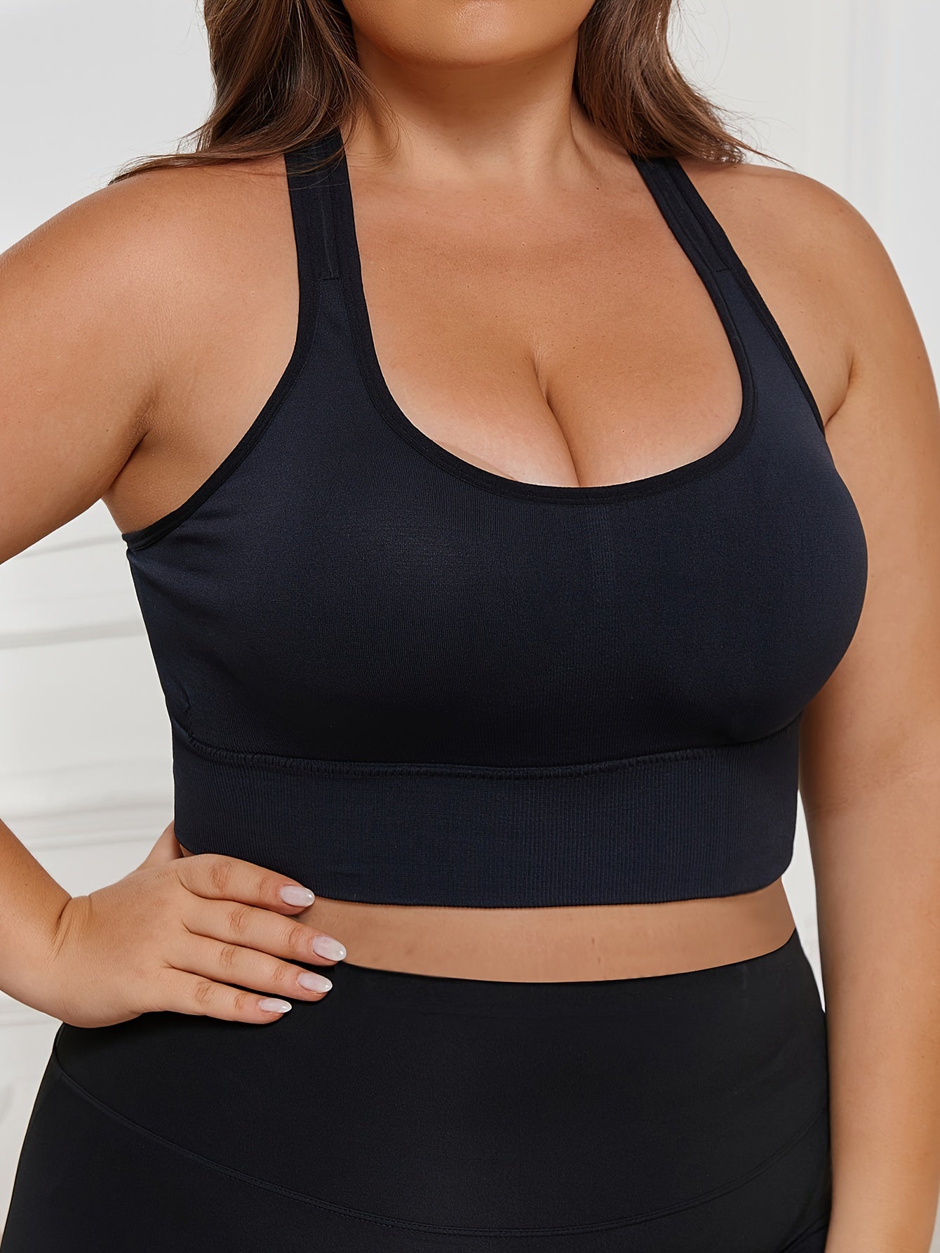 Plus Size Seamless Sports Bra made of solid color knit fabric with medium stretch, composed of 83% polyamide and 17% elastane. Features removable padding, wireless design, and a lightweight