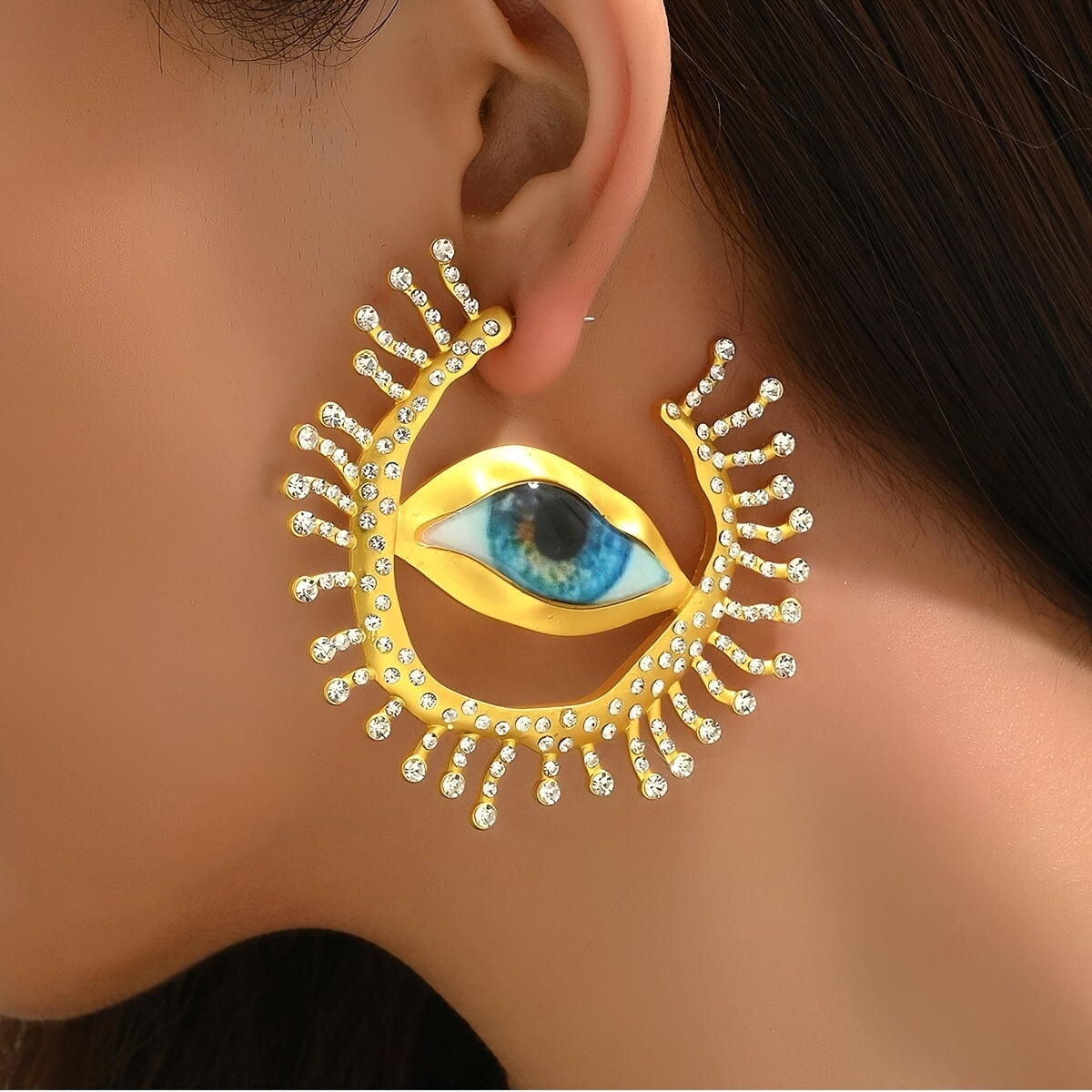 These punk cool style statement earrings feature an exaggerated eye-shaped design with metallic rhinestones. Perfect for parties, vacations, and everyday wear. Add a unique touch to your jewelry collection with this bold pair of dangle earrings.