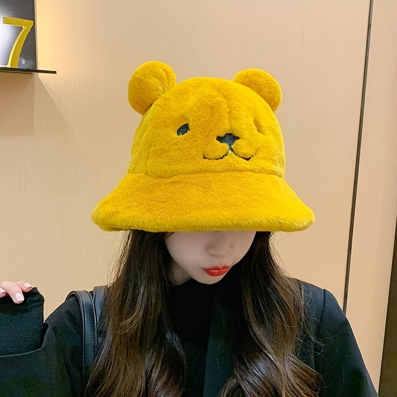 Women's fuzzy bucket hat with cute bear embroidery in yellow and white. Hand washable for cozy winter wear.