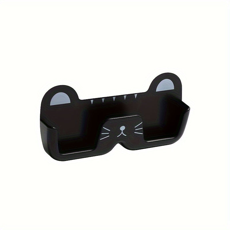 Wall-mounted whimsical cat eyeglass holder made of punch-free plastic, designed to store and display glasses in a space-saving and fashionable manner.