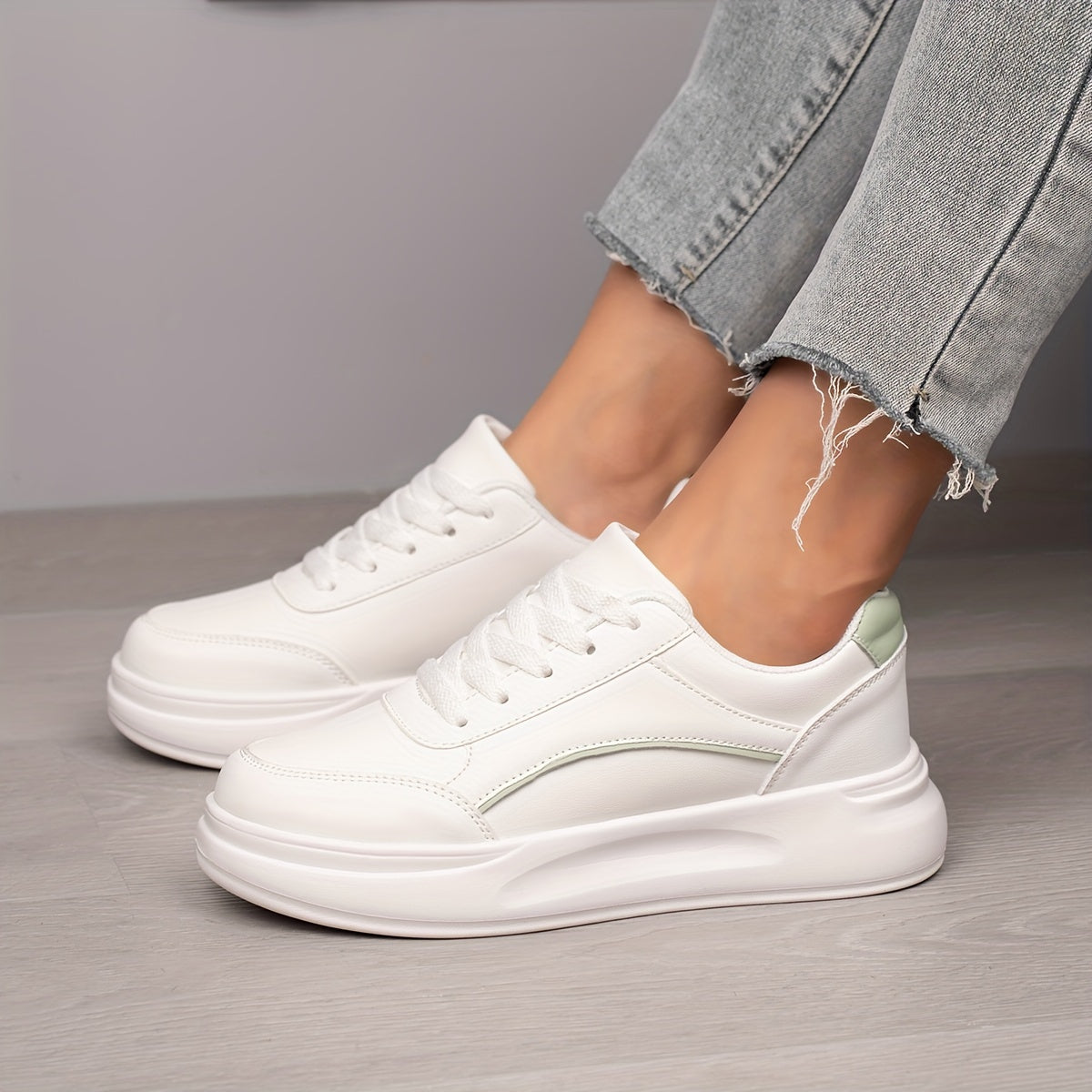 Women's white skate shoes with round toe, lace up closure, and low top flat design. Comfortable for casual wear and sports.