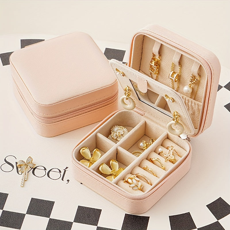 Compact and stylish portable jewelry box with mirror, zipper, and flip cover. Ideal for storing rings, earrings, and necklaces on-the-go.