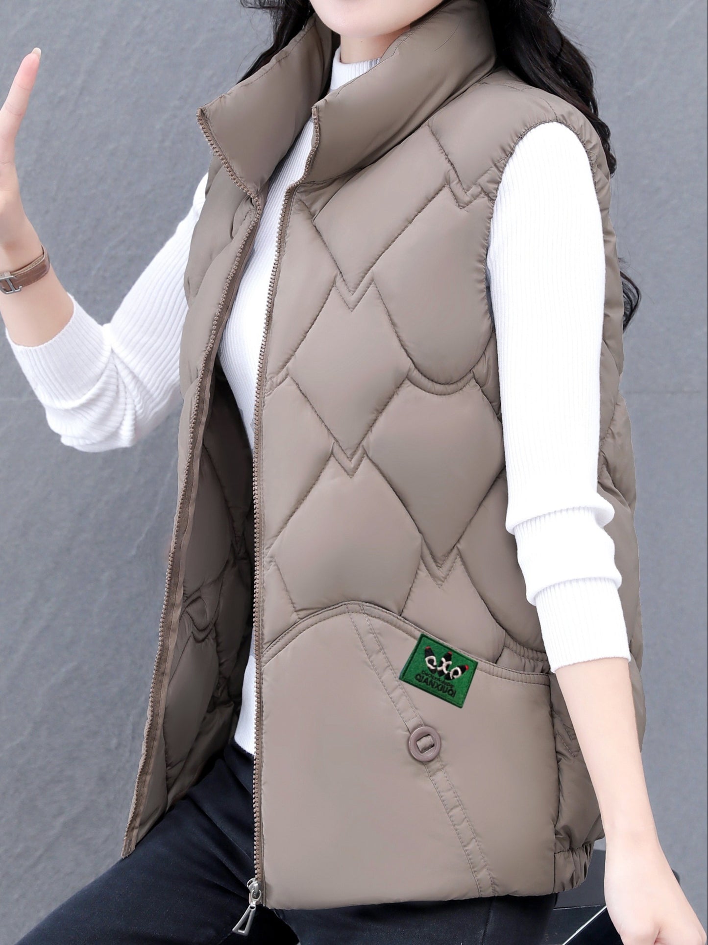 Women's polyester vest with quilted stand collar, zipper closure, pleated hem, and loose fit. Ideal for fall/winter casual wear with a Middle Eastern style.