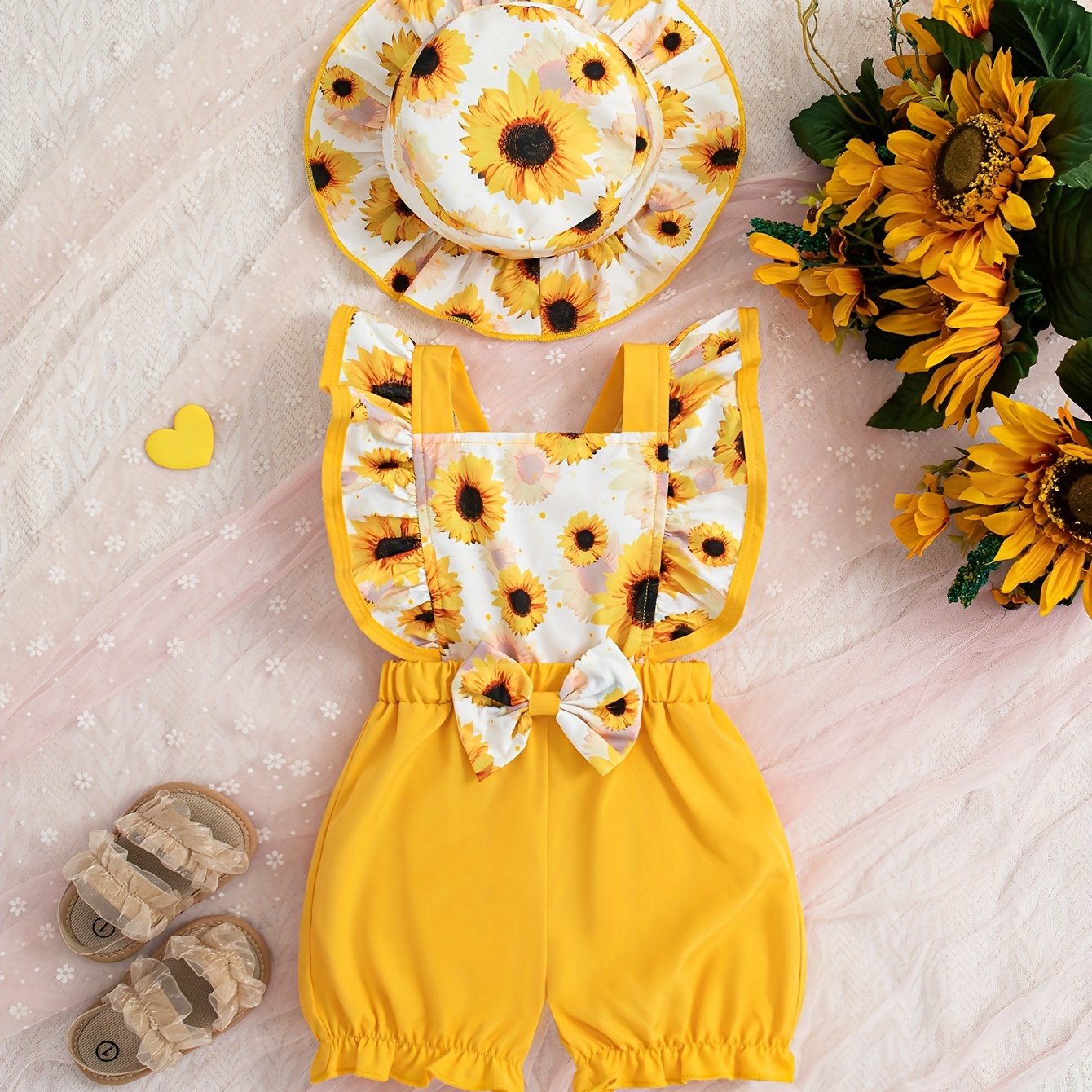 Cute sunflower and butterfly print baby girl jumpsuit with bow detail and matching hat. Made of polyester, machine washable. Perfect for summer and outdoor activities.