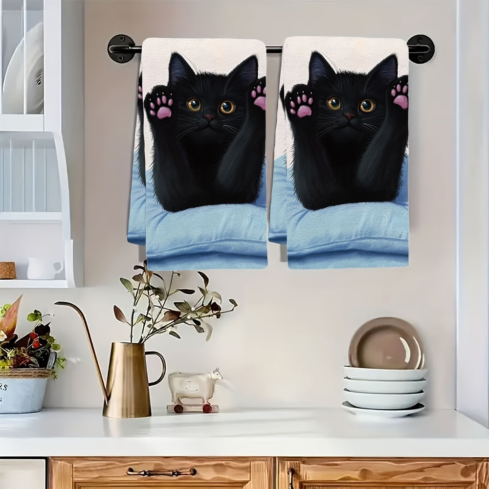 This pair of ultra-soft kitchen towels showcases a black cat stretching on a pillow, with its front paws and pink claws on display. These highly absorbent dish towels are ideal for holiday decoration and can be easily machine washed. The towels measure