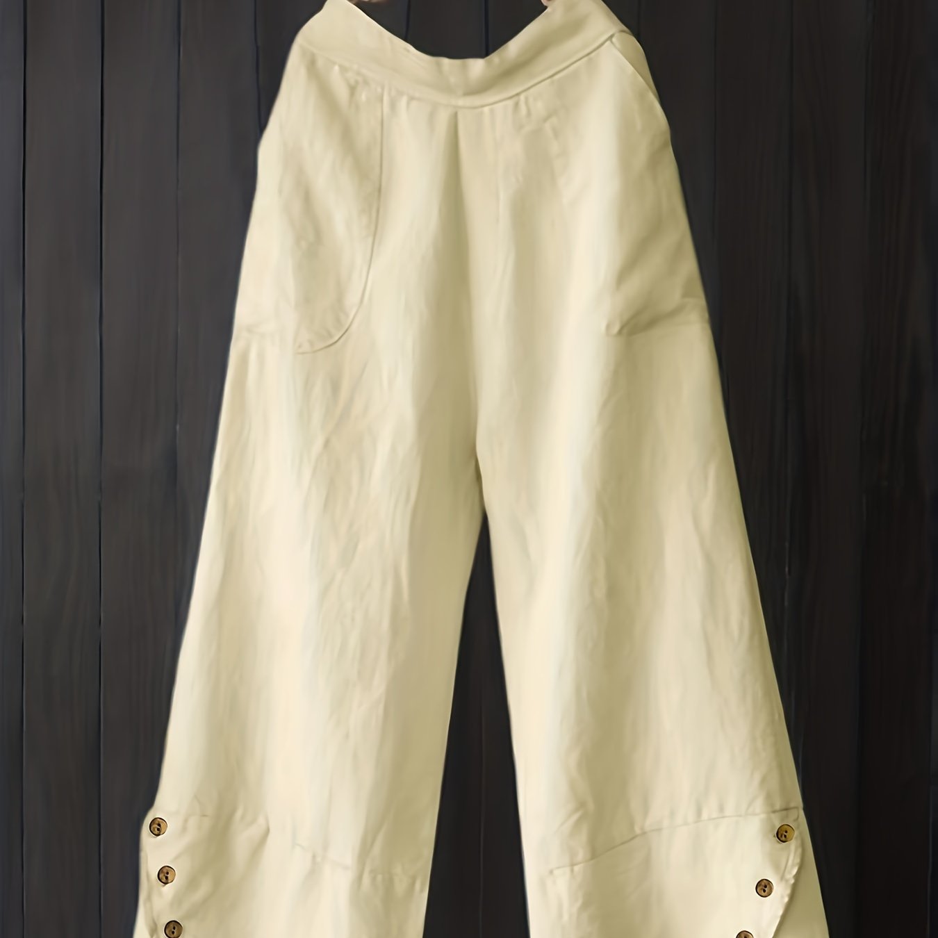 Stylish high-waisted plus-size cotton trousers with pockets, button details, solid color, and wide legs.