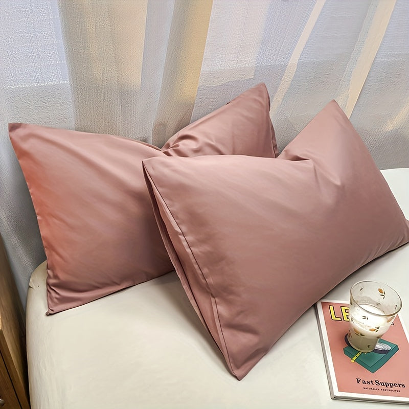 Two polyester pillowcases for bedroom use, featuring a multi-colored solid design.