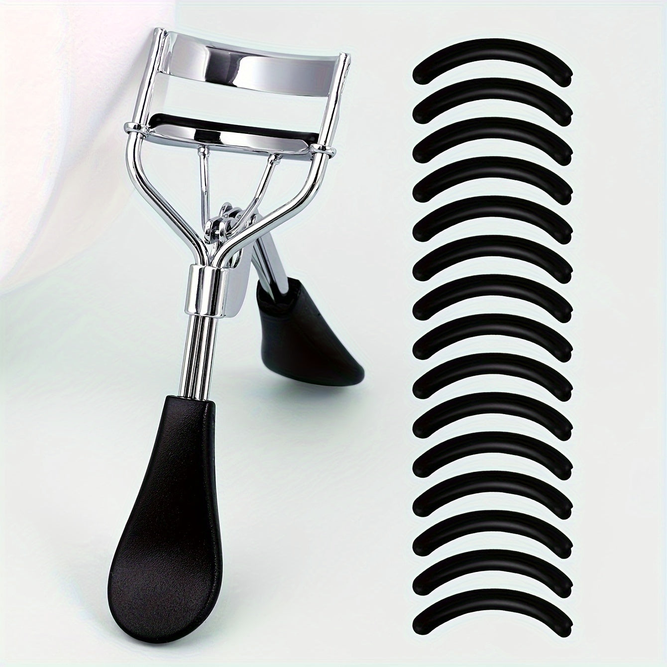 Portable eyelash curler with stainless steel handle, 15 silicone pads for curling and shaping without damaging lashes. Ideal for lifting and creating big, beautiful eyes on women.