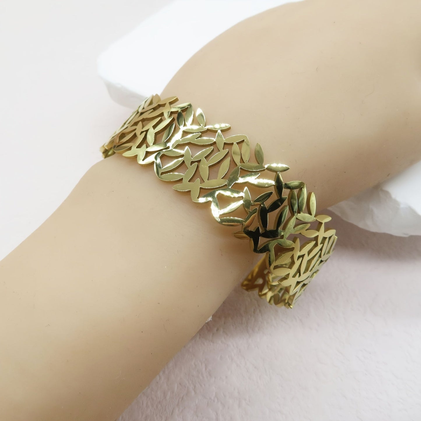 A stylish stainless steel bangle for women, featuring a delicate two-tone design with an irregular hollowed-out leaf bird's nest pattern. This fashionable botanical accessory is perfect for adding a touch of elegance to any outfit and makes a great gift