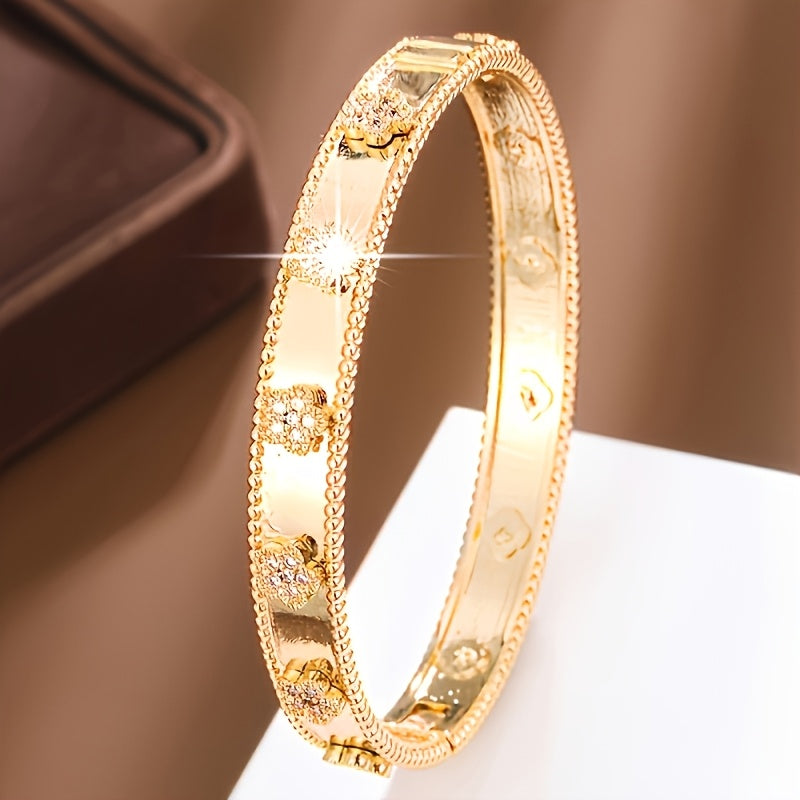 This elegant bangle bracelet is inspired by French design and features a beautiful golden tone with floral print and cubic zirconia accents. It is a classic copper hand jewelry piece perfect for daily wear and music festivals, showcasing a stylish plant