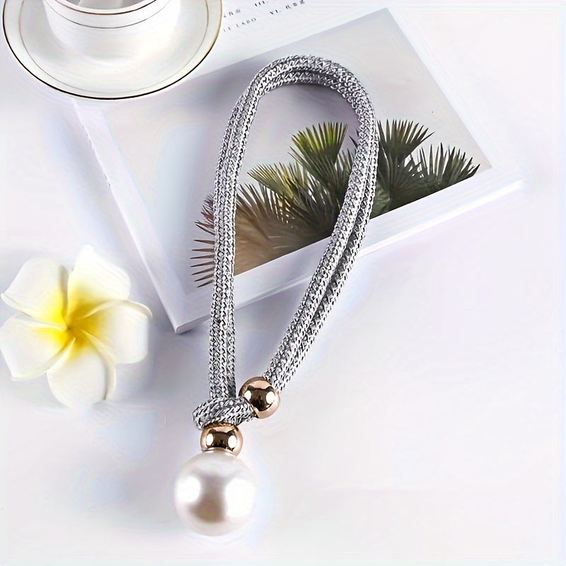 A faux pearl curtain tieback, perfect for holding back your living room curtains and adding a touch of elegance to your home or office decor. This decorative accessory is a stylish way to keep your curtains neatly stored when not in use.