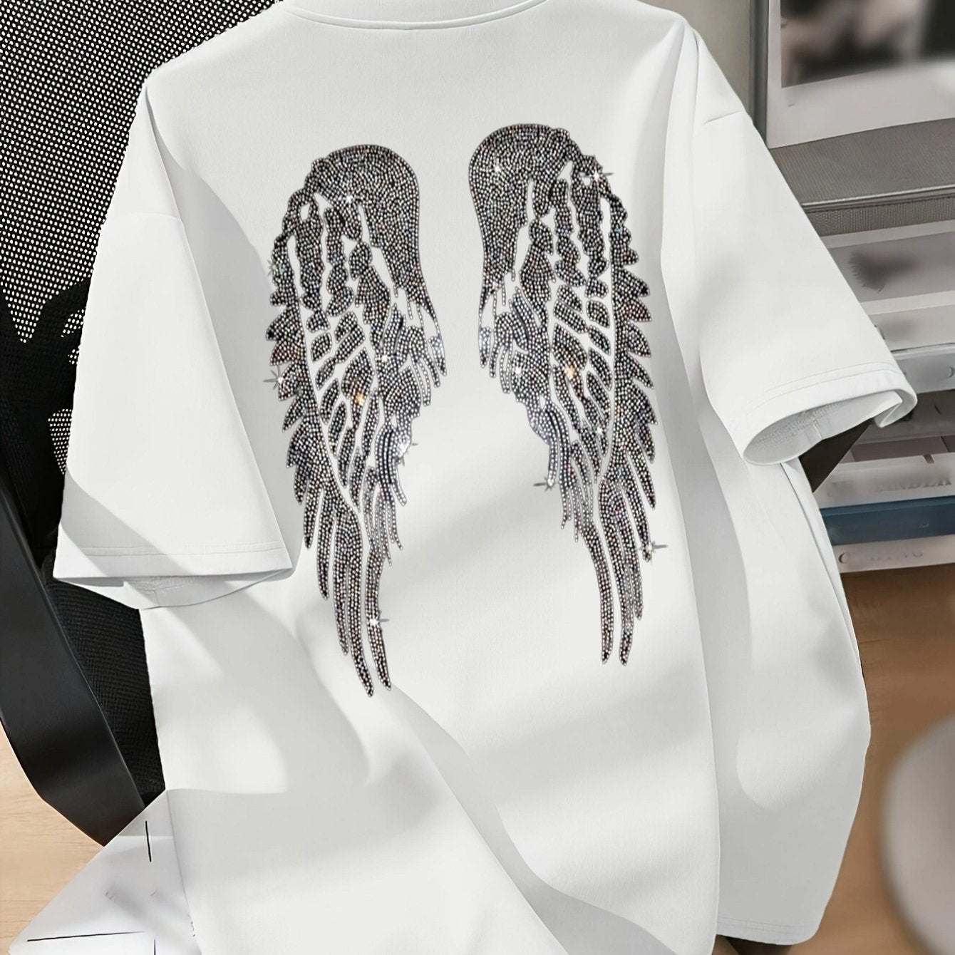 White graphic tee with angel wings design. Casual crew neck, short sleeve. Stretchy polyester blend, machine washable. Perfect for spring & summer. Stylish wearable art.