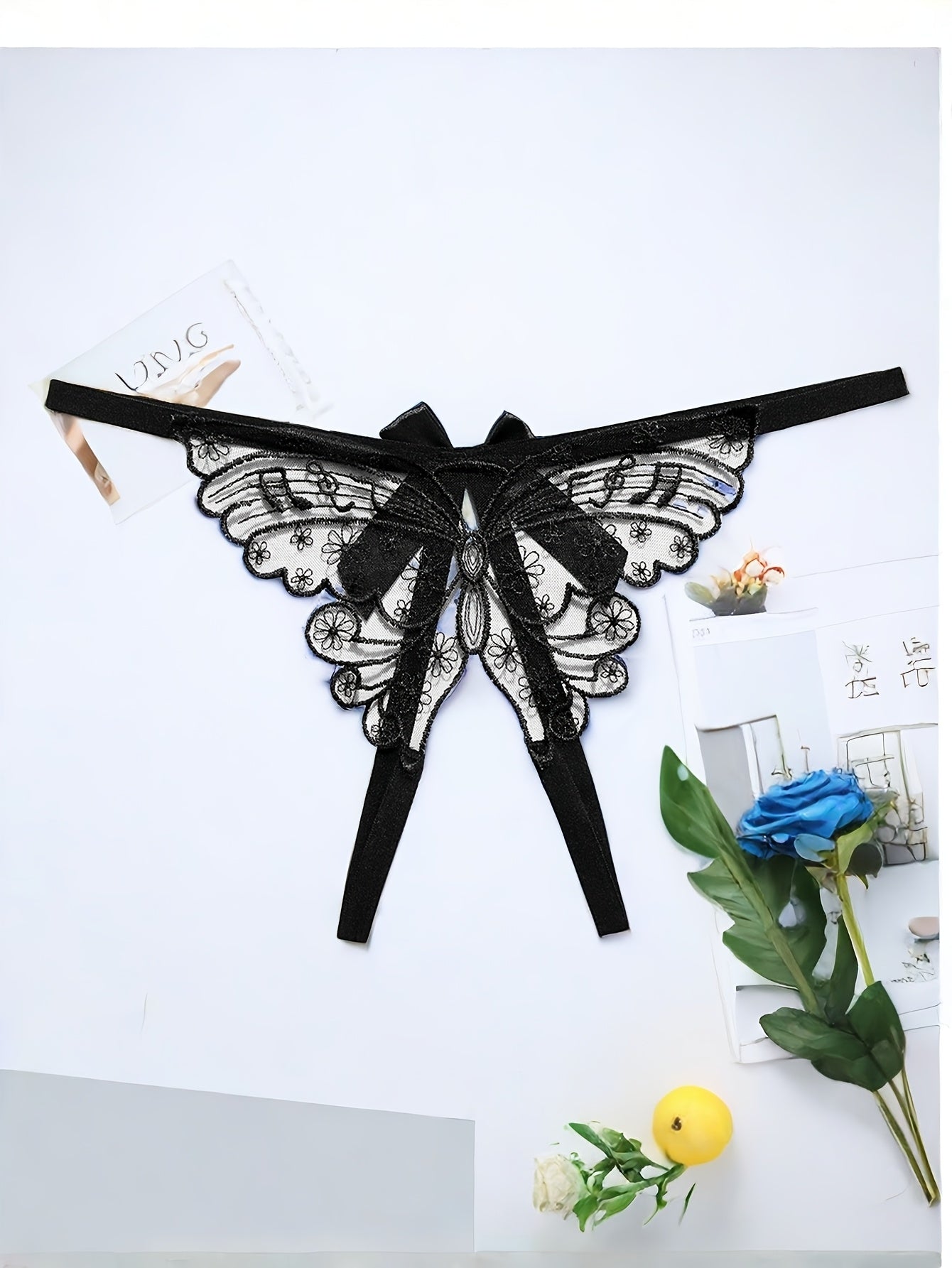 Adults' elegant butterfly embroidery mesh thong with split crotch and bow detail, made of knit fabric.