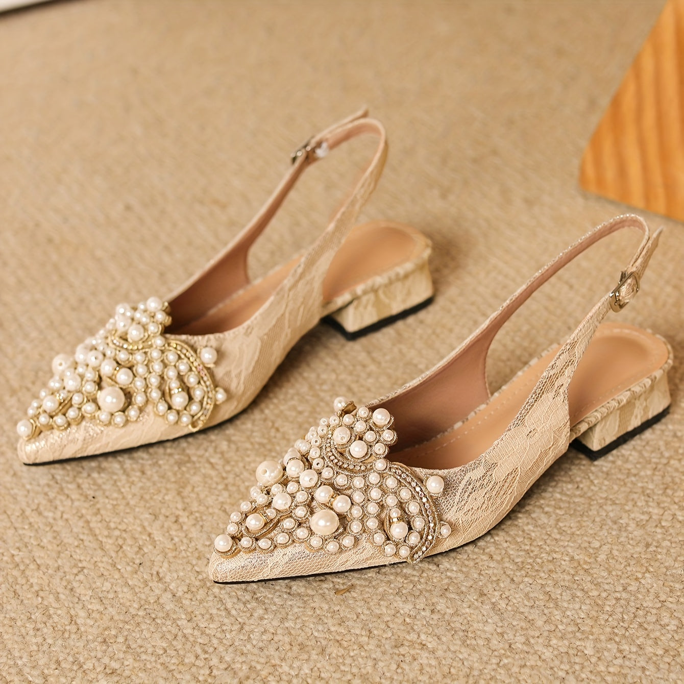 Women's low heel shoes with faux pearl decoration, point toe design, and buckle strap.