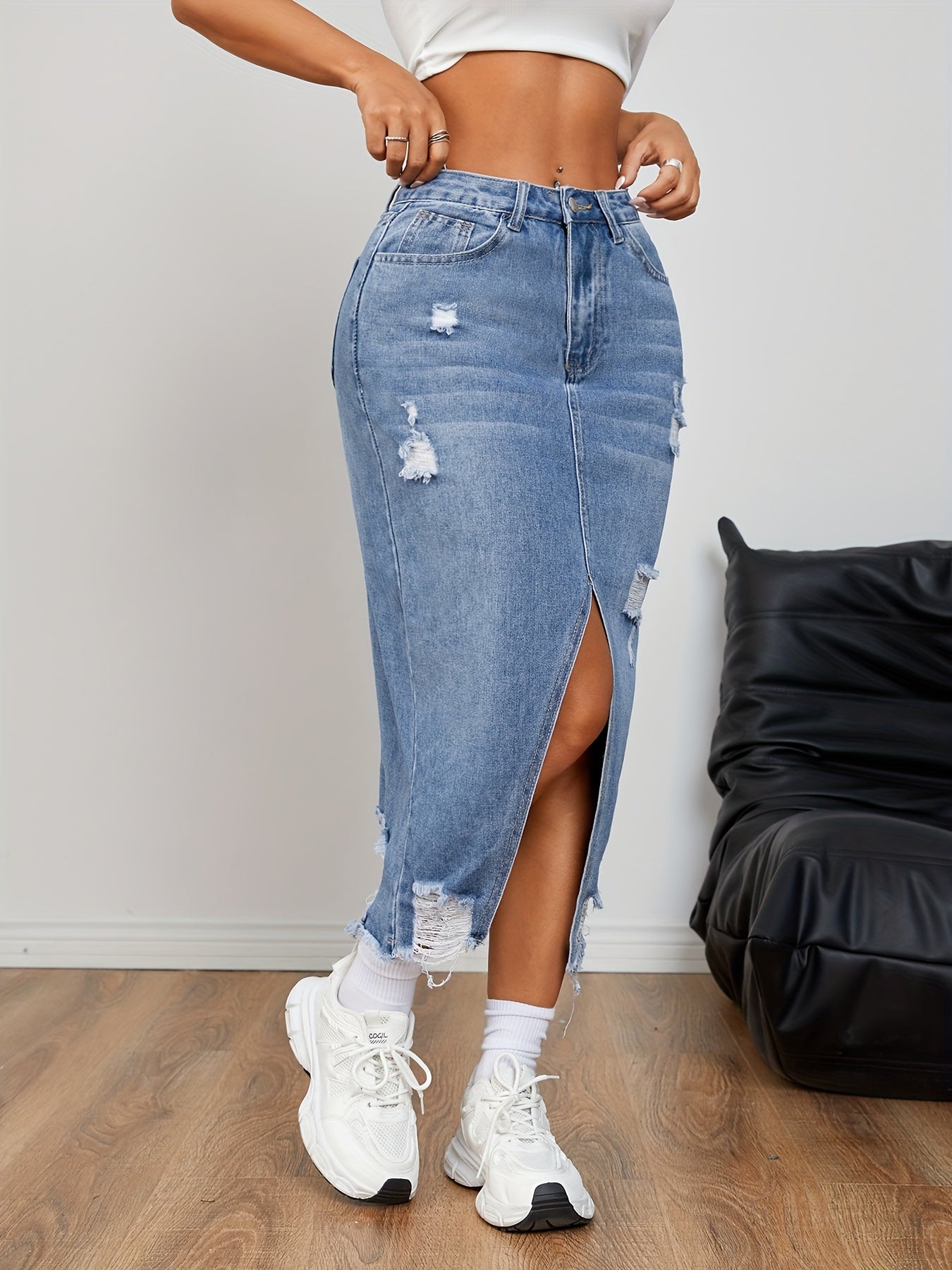 Casual distressed denim skirt with raw hem and slit for women.