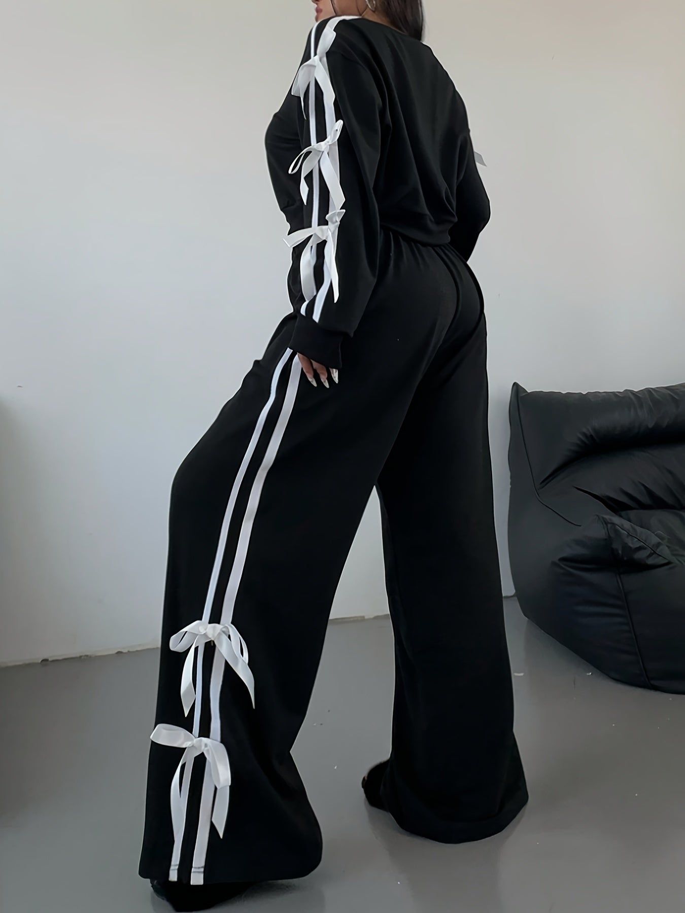 New two-piece set for plus size women with crop top, long sleeves, striped wide-leg pants, bow, and drawstring decorations.