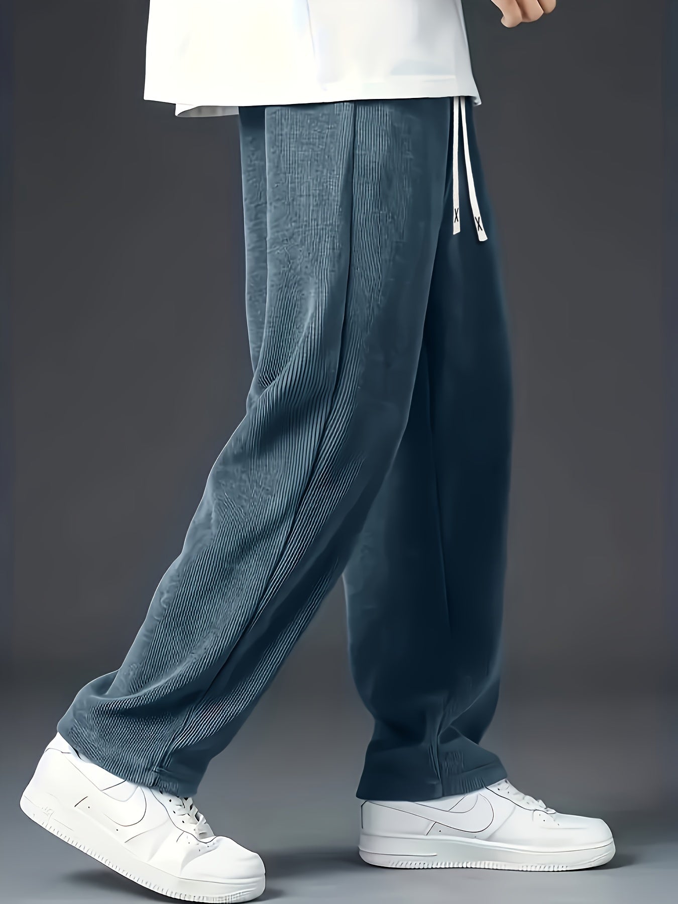 Loose straight-leg corduroy sweatpants in solid color, made of polyester blend with pockets and non-stretch fabric.