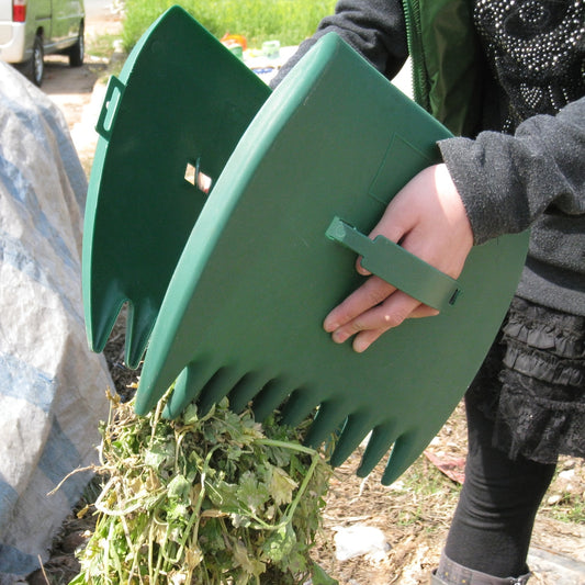 Pair of large plastic leaf scoops for picking up leaves, grass clippings, and debris. Durable gardening hand tools.