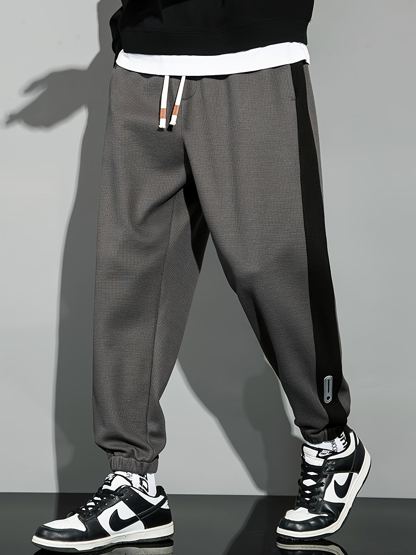 Men's casual joggers with contrast side stripe, elastic waist drawstring, regular fit tapered leg for leisure.