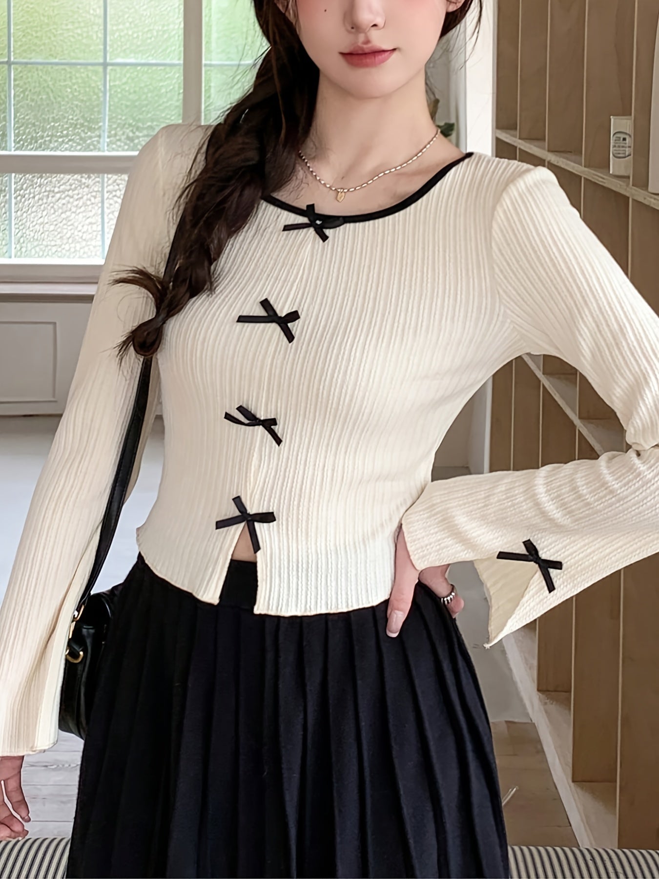 Chic women's long sleeve t-shirt with bow detail, side slit, crew neck, ribbed texture, and a polyester blend - perfect for spring and summer.