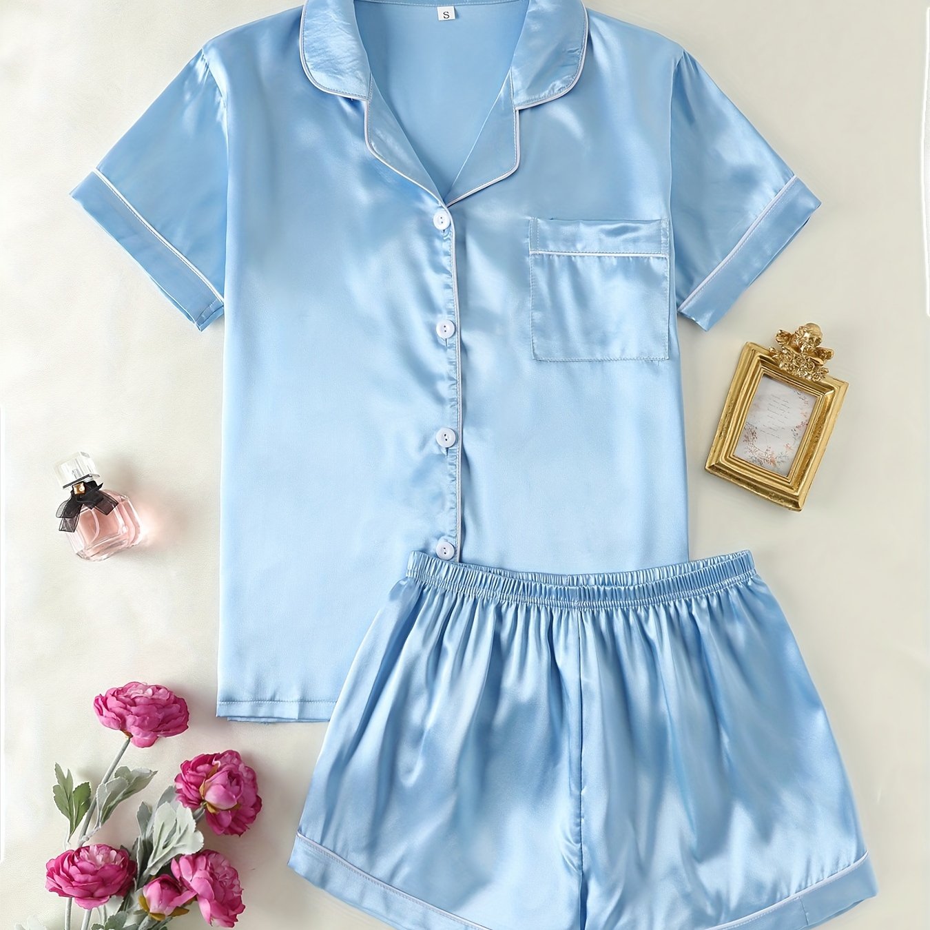 Satin lounge set includes a short sleeve button-up top with lapel collar and elastic shorts.