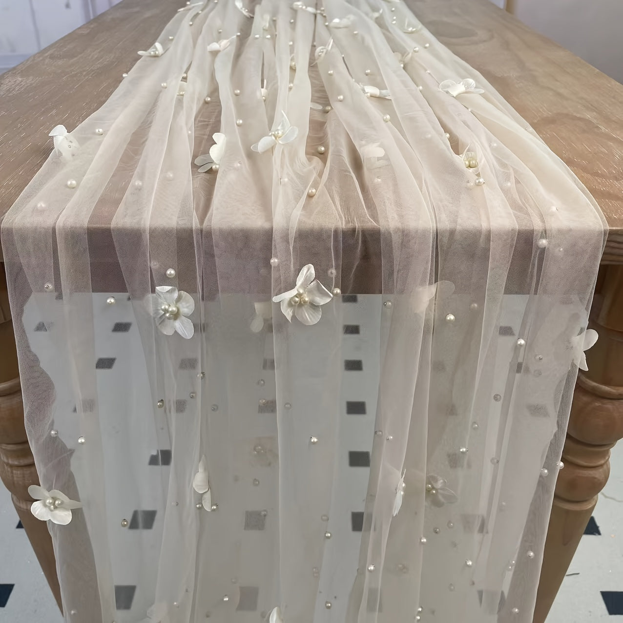 Elegant pearl bead tulle table runner, perfect for weddings and parties. Can also be used as a chair sash or backdrop drape. Made from 100% polyester fabric with delicate bead detailing.