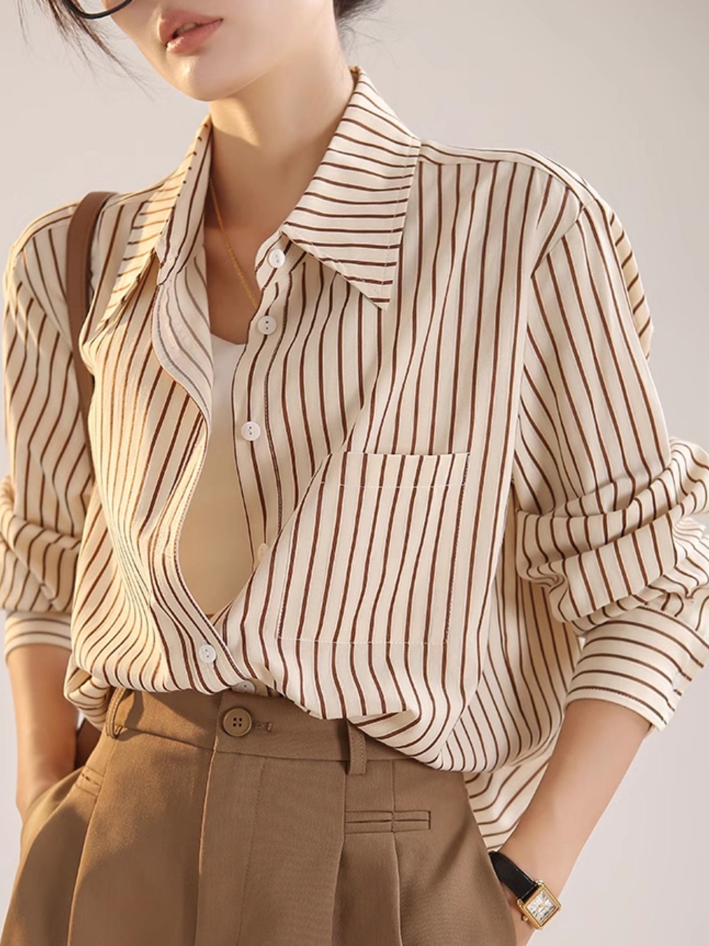 Elegant striped button-up shirt for women with a French-inspired design in beige and brown vertical stripes for spring/summer.