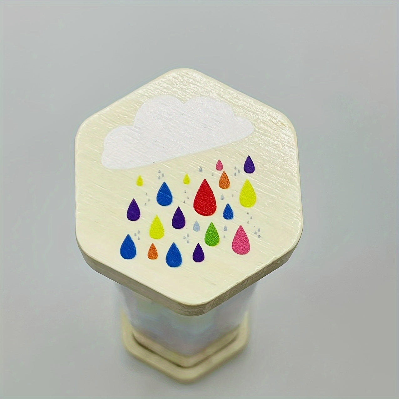 Musical instrument for babies that simulates the soothing sound of rain in a wooden tube, similar to a rainbow hourglass sandbell.