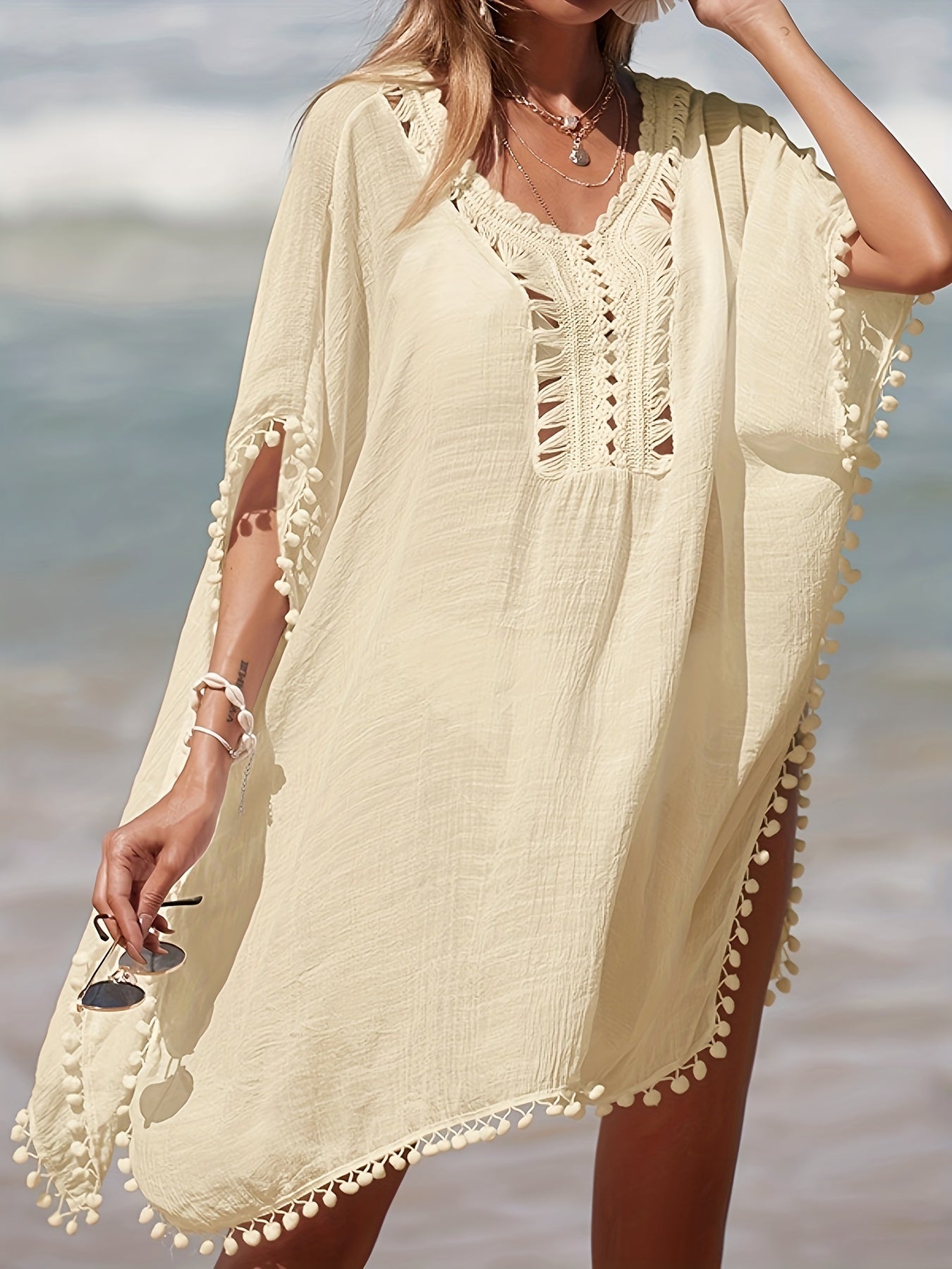 Bohemian style crochet cover up with batwing sleeves, side split, and sheer fabric for beach sun protection.