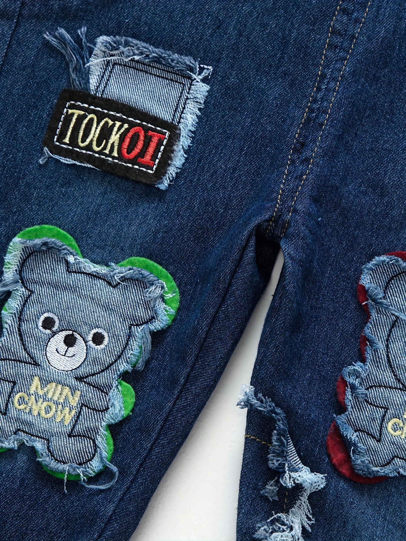 Children's denim overalls with embroidered animal designs, made of a cotton blend with slight stretch, suitable for outdoor wear in the spring and fall.