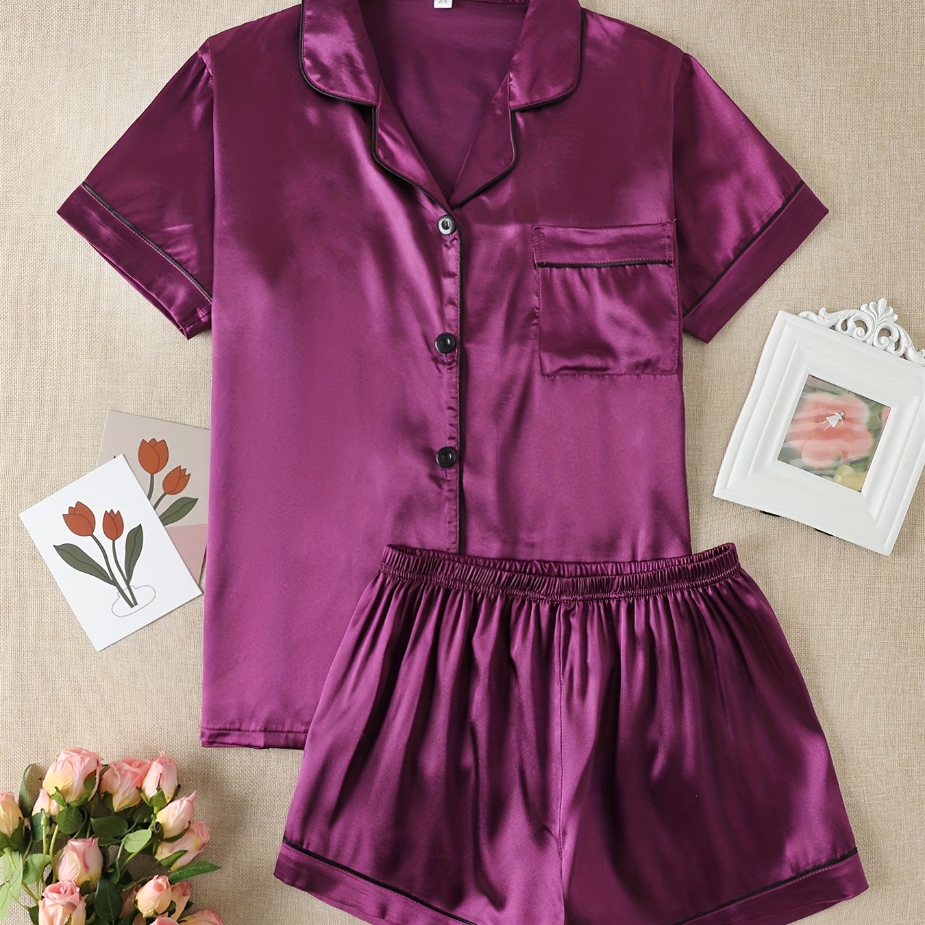 Satin lounge set includes a short sleeve button-up top with lapel collar and elastic shorts.