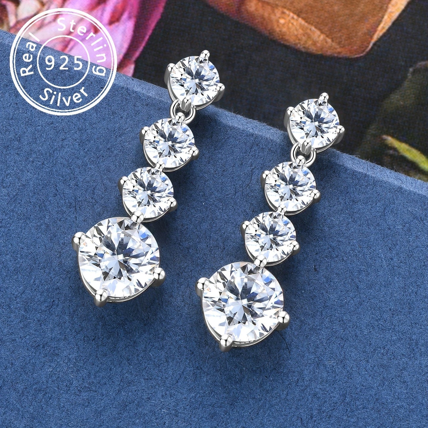 These elegant earrings feature a pair of 925 sterling silver earrings with a single 8mm round Mozambique stone pendant. The D color stones are perfect for any occasion, whether it be for an engagement, wedding, or birthday gift. The earrings weigh