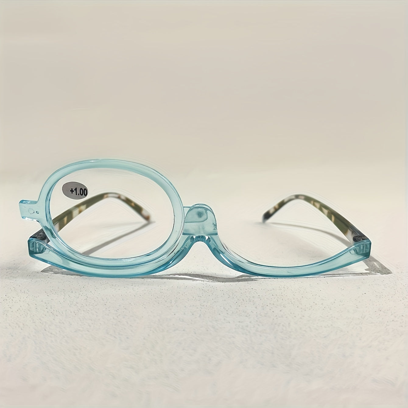 Rotating cosmetic reading glasses for makeup application, covering prescription range +1.0 to +4.0.