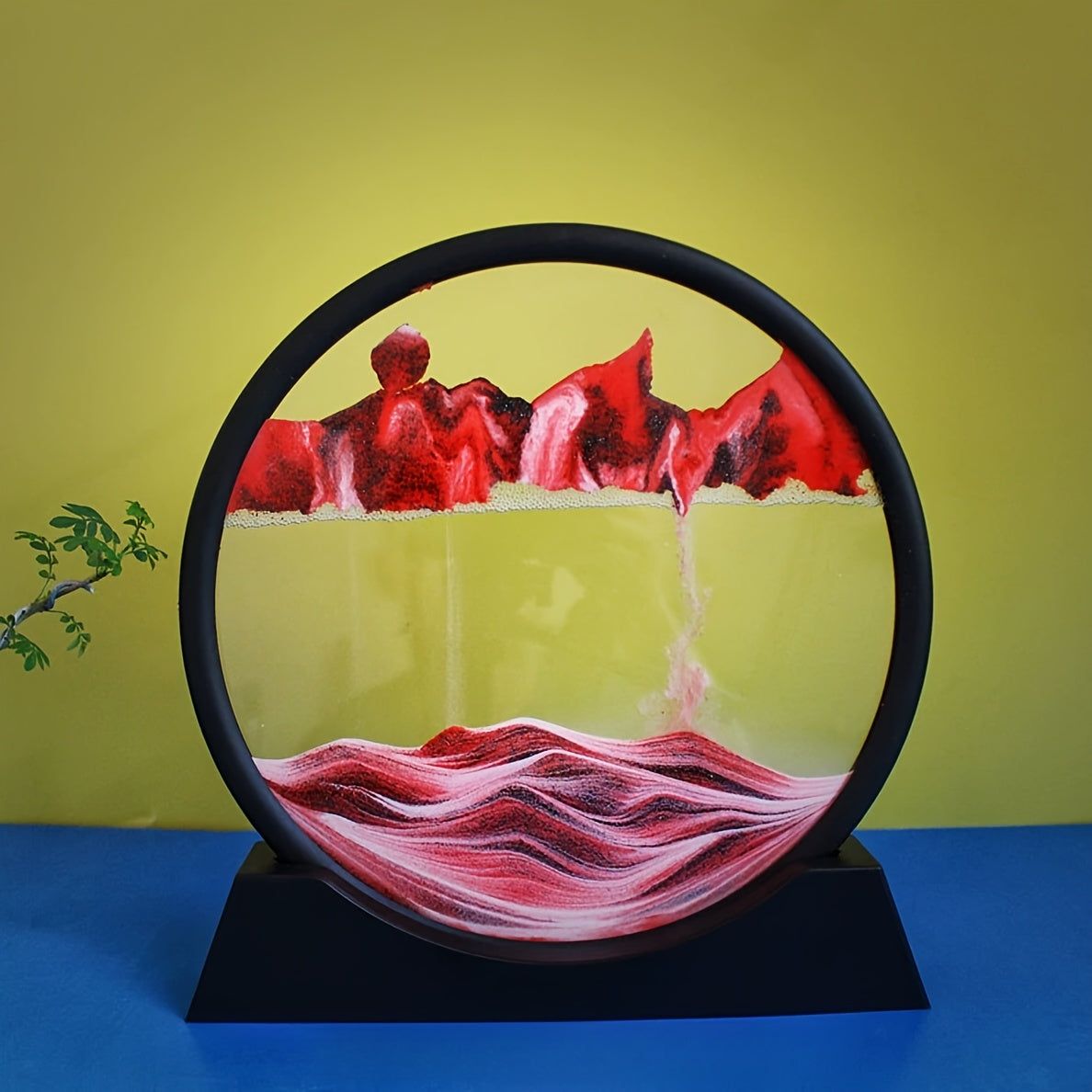 Large round glass frame with flowing sand creates a 3D deep sea scene as a relaxing home and office decoration.