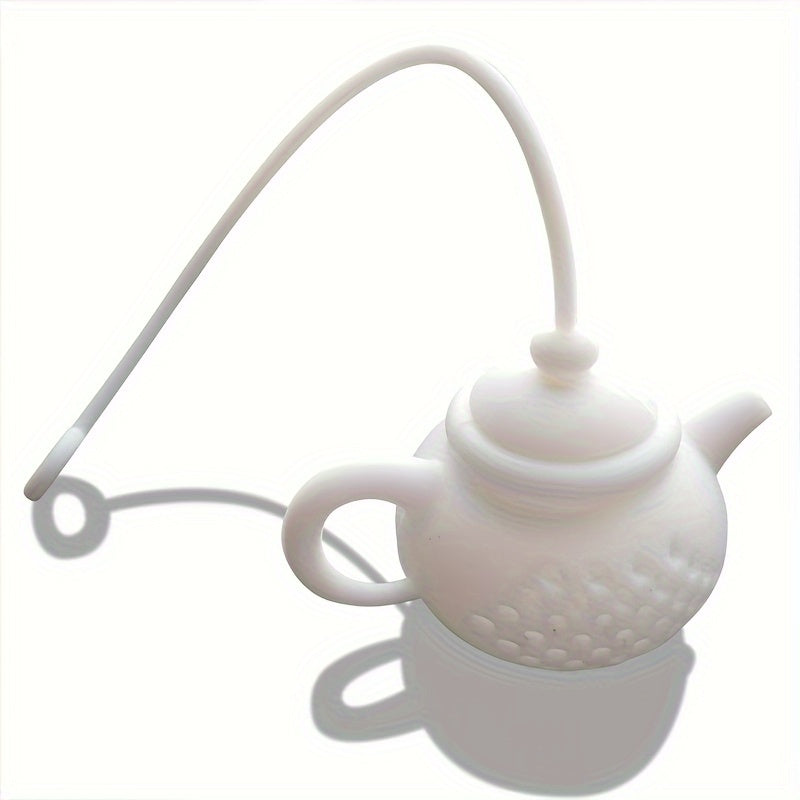 Reusable teapot-shaped tea infuser made of silicone for loose leaf tea, ideal for kitchen and dining use, small in size suitable for making tea.