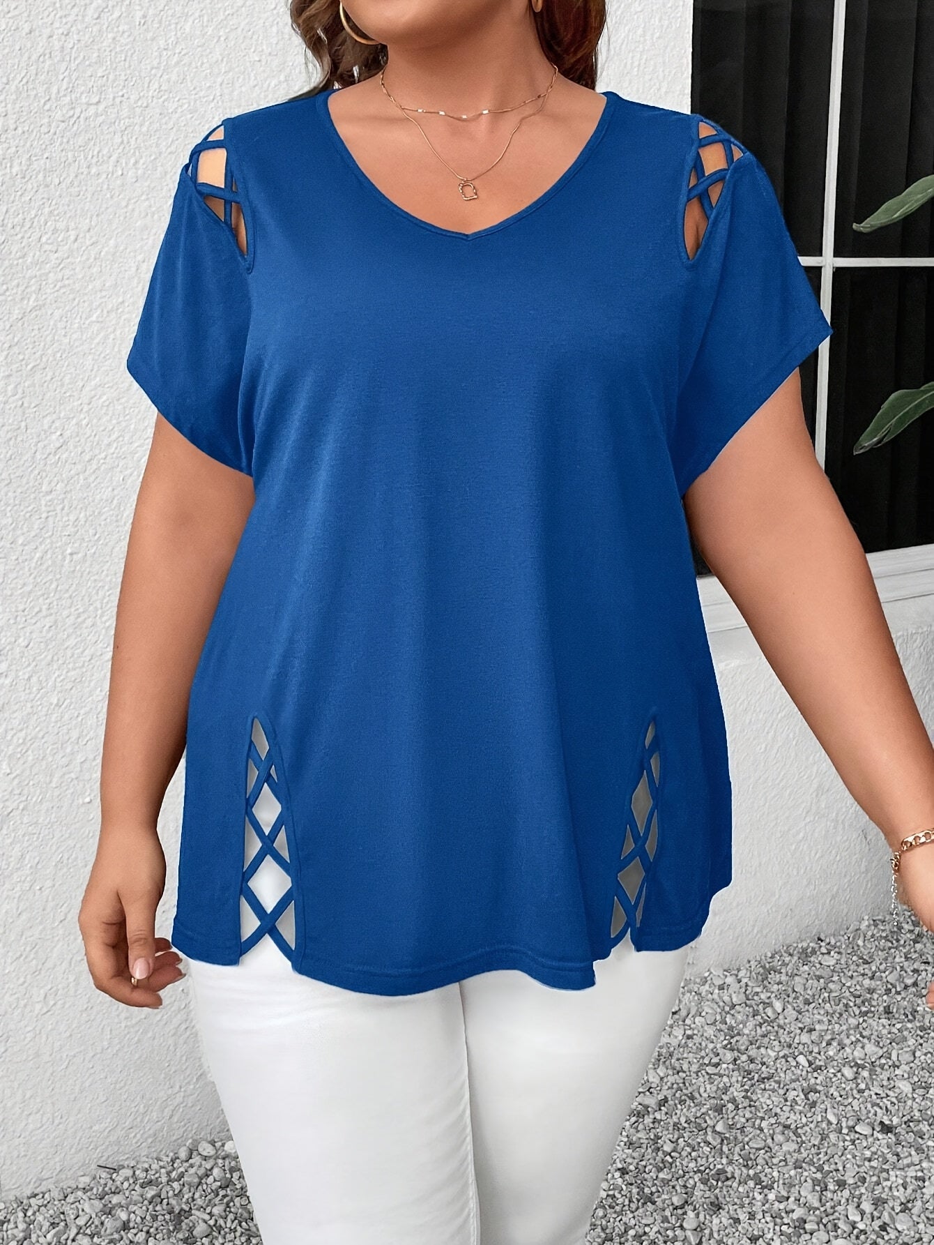 Stylish plus-size women's top with V-neck and crisscross detail, made of medium-stretch fabric, suitable for all seasons.