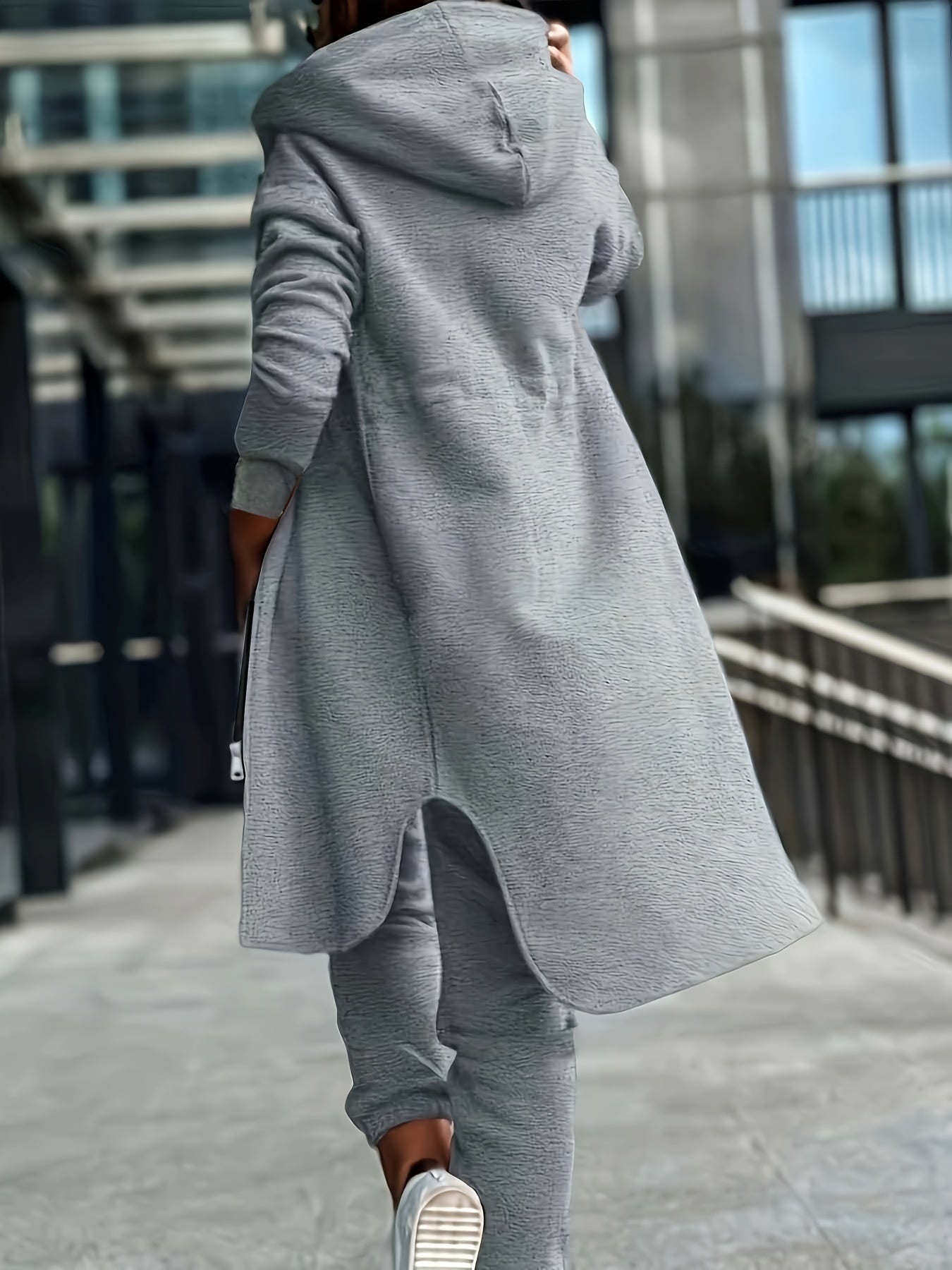 Heather Gray hoodie and jogger set for plus size women. Features zip-up long sleeve top with asymmetrical hem and drawstring pants. Made of a polyester blend and machine washable.