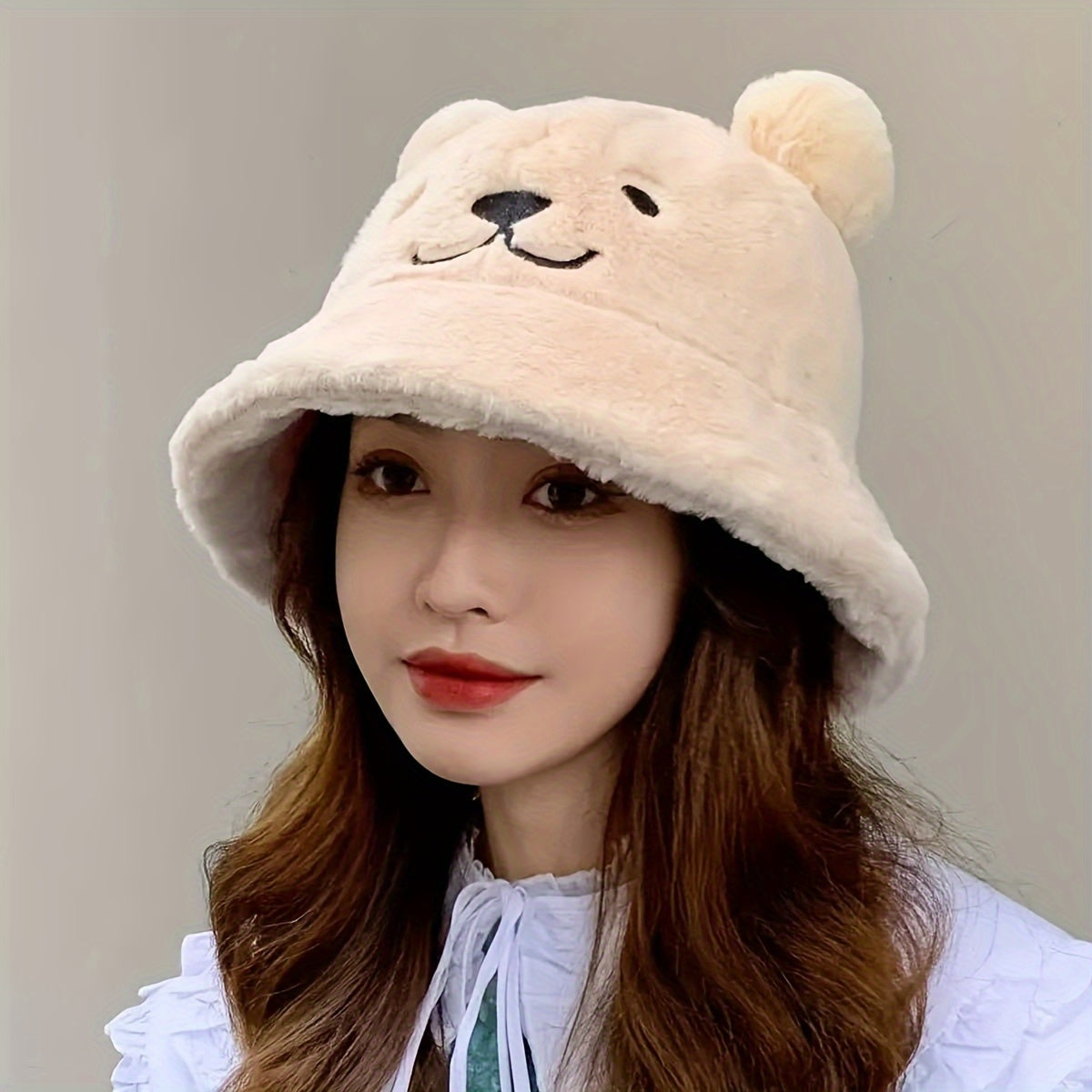 Women's fuzzy bucket hat with cute bear embroidery in yellow and white. Hand washable for cozy winter wear.