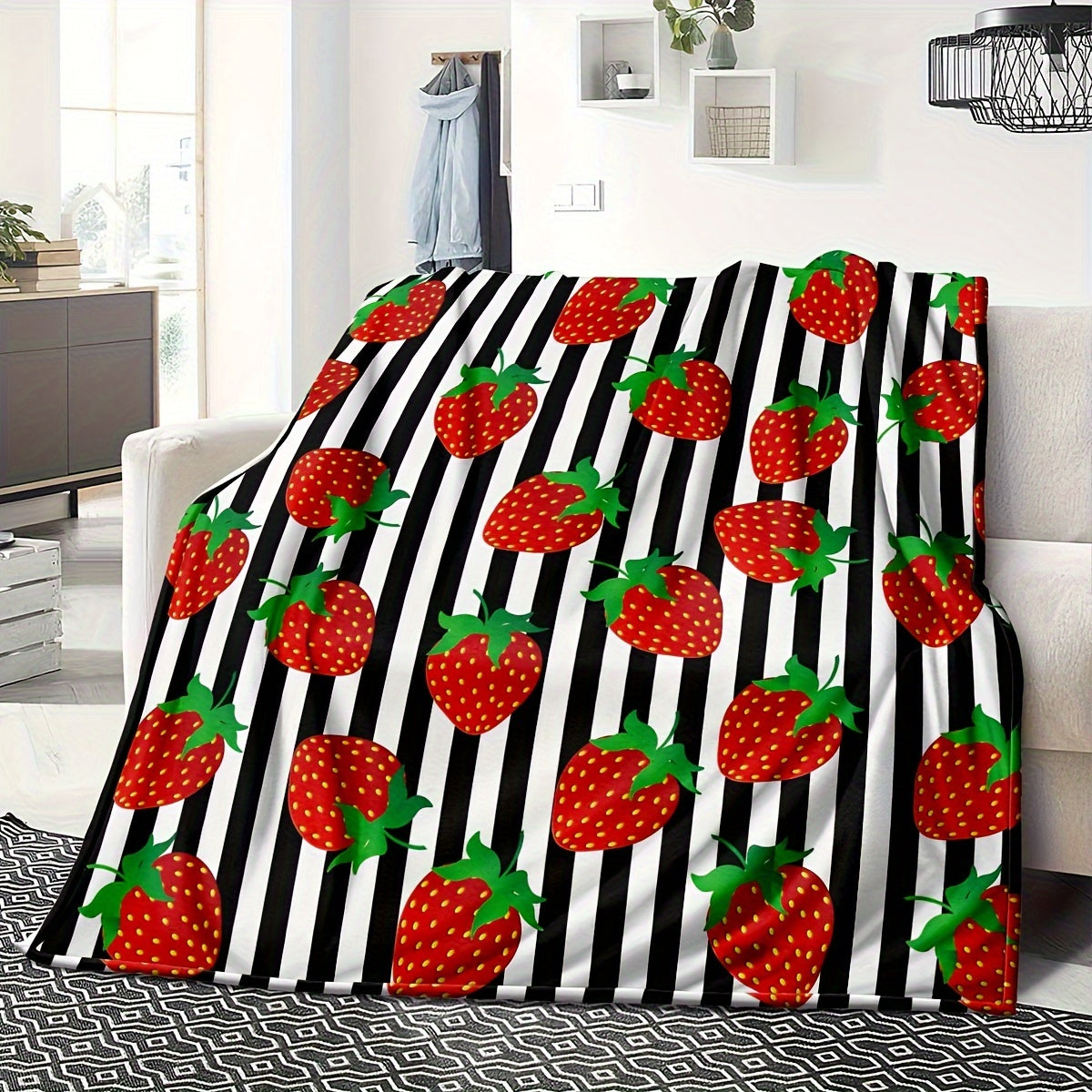 Black striped 1-piece Strawberry Printed Fleece Throw Blanket made from soft microfiber material with a durable twill weave. This all-season blanket features a digital print, is lightweight, and weighs between 250-300g. Perfect for adding a touch of