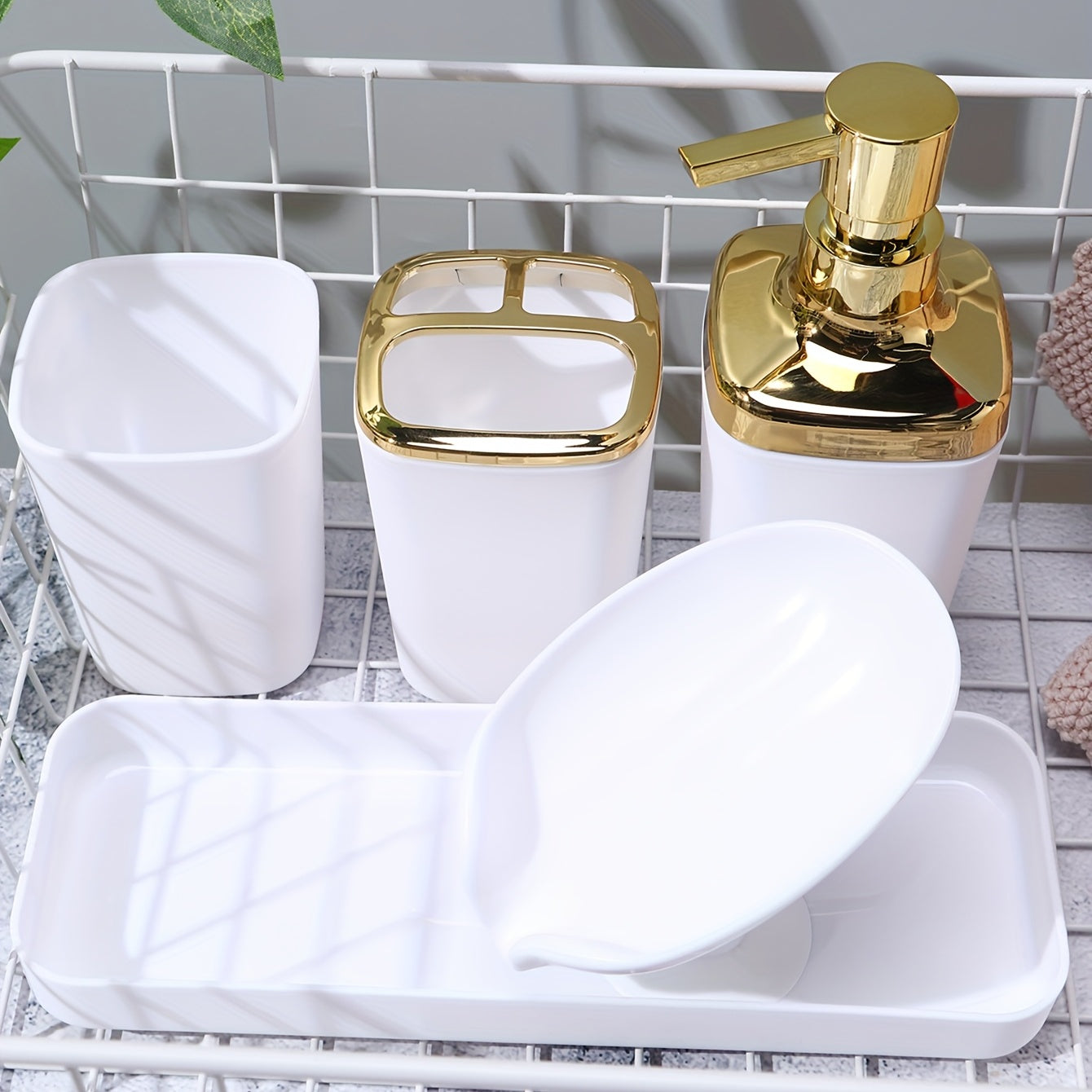 Stylish 5-piece black bathroom set with golden accents, includes lotion dispenser, toothbrush holder, cup, soap dish, and tray made of sleek plastic for elegant home decor.