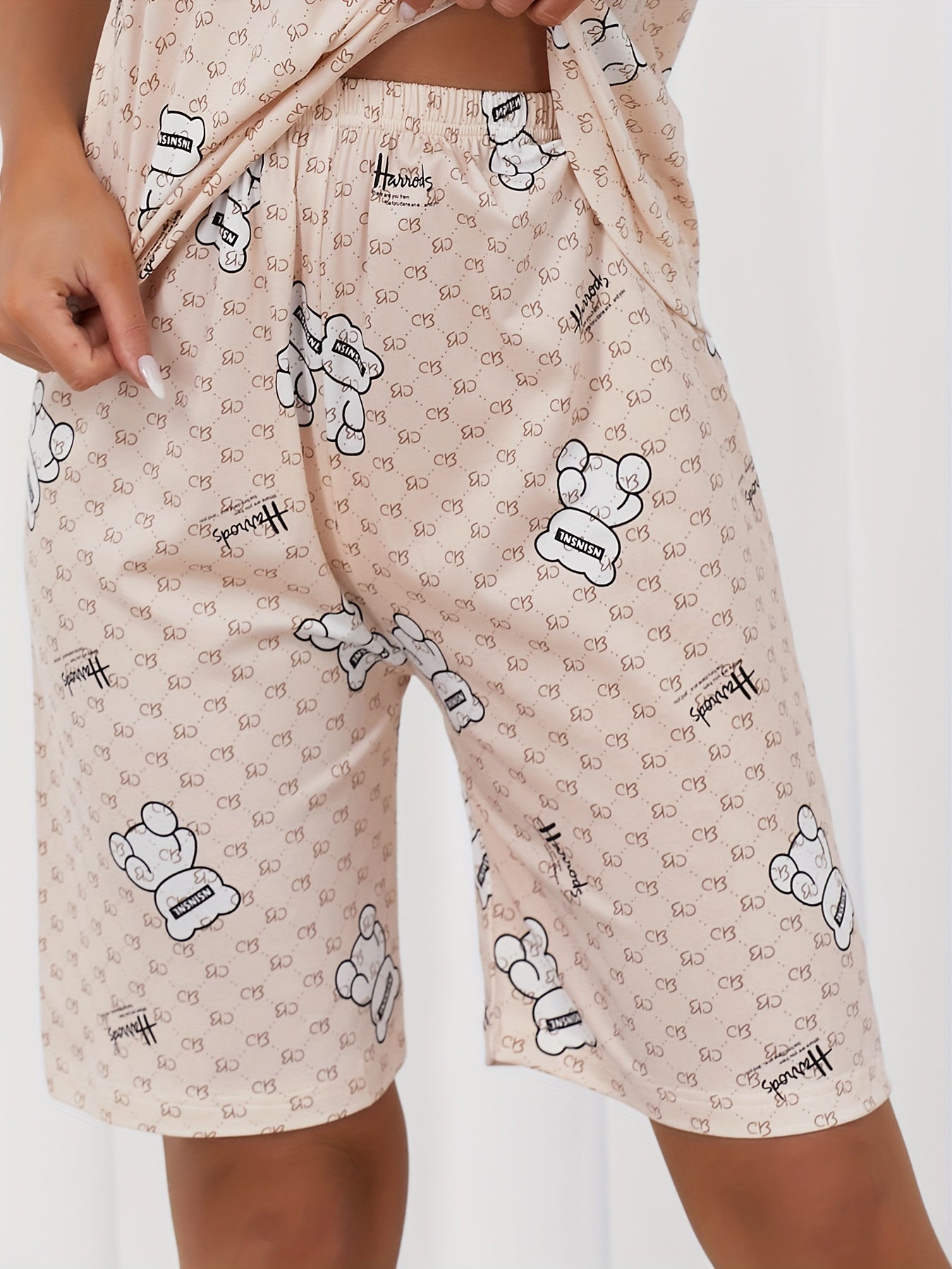 Women's sleepwear set featuring a cute bear and letter print, short sleeve top, and capri pants with a crew neck.