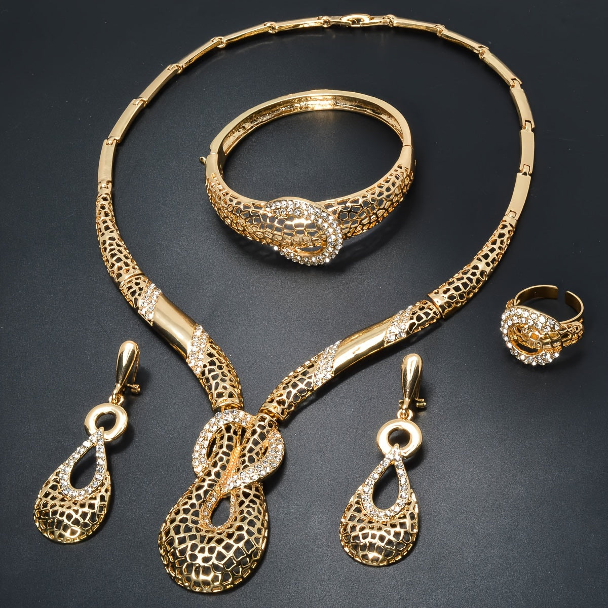 ZEADEAR presents a sophisticated gold-tone jewelry set featuring geometric cutouts. This luxurious collection includes a stunning Y-shaped necklace, bracelet, earrings, and ring, ideal for weddings and parties.