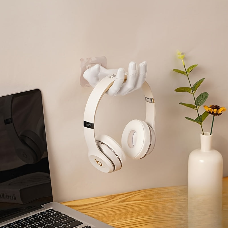 Palm-shaped adhesive wall hook for strong, no-drill, traceless storage of keys and headphones at home.