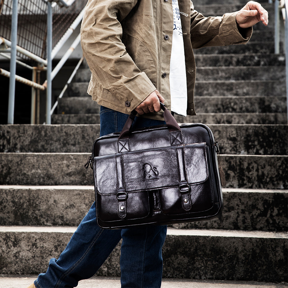 Brown leather briefcase with multiple compartments, adjustable shoulder strap, suitable for travel and professional activities.