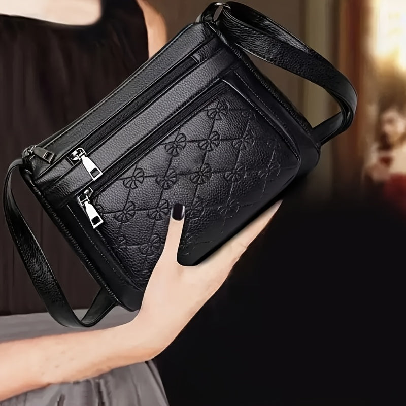 Chic black crossbody bag for women, featuring embossed floral design and bow accent. Ideal for daily use.