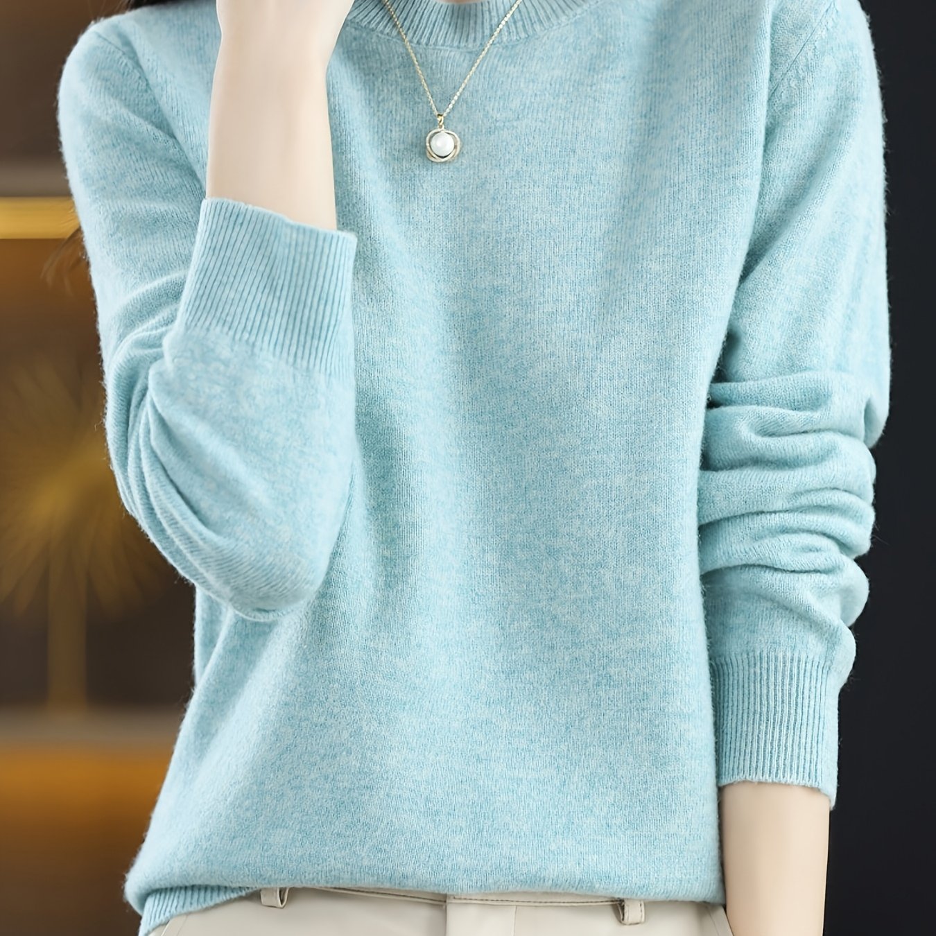 Stylish women's merino wool sweater with cozy crew neck, long sleeves, and solid color knit design for fall/winter.