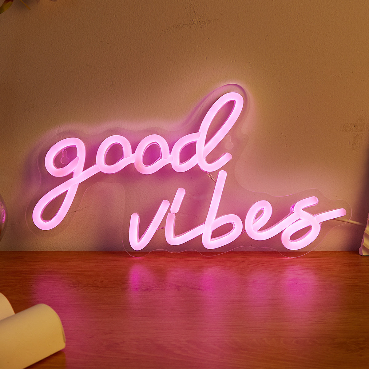 Pink cursive "Good Vibes" LED neon sign, USB powered for wall decor in bedroom, bar, or party atmosphere.