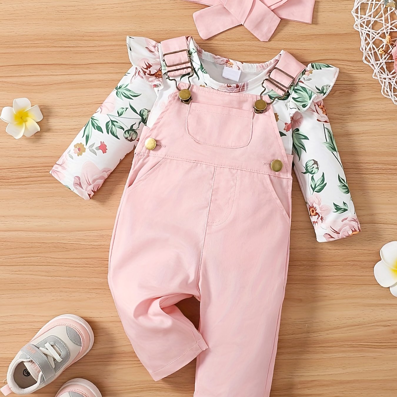 Girls 3-piece cotton set includes adjustable strap pants with pockets, floral print long sleeve romper with ruffle shoulder, and bow headband. Perfect for outdoor wear in spring/fall.