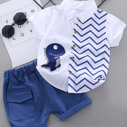 Boys' Dinosaur Cartoon Shirt & Shorts Set in soft cotton blend with white short-sleeve top and blue chevron pattern. Includes dark blue denim shorts for a casual summer outfit. Ideal for