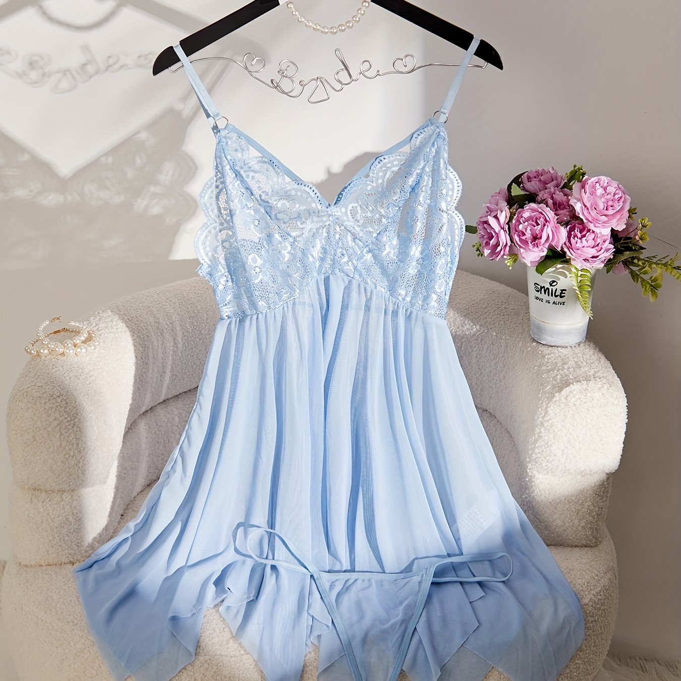 Feminine lace and sheer slip dress set with matching thong, perfect for special occasions and intimate moments. Features V-neck with ruffle detail, made of polyester blend, and hand